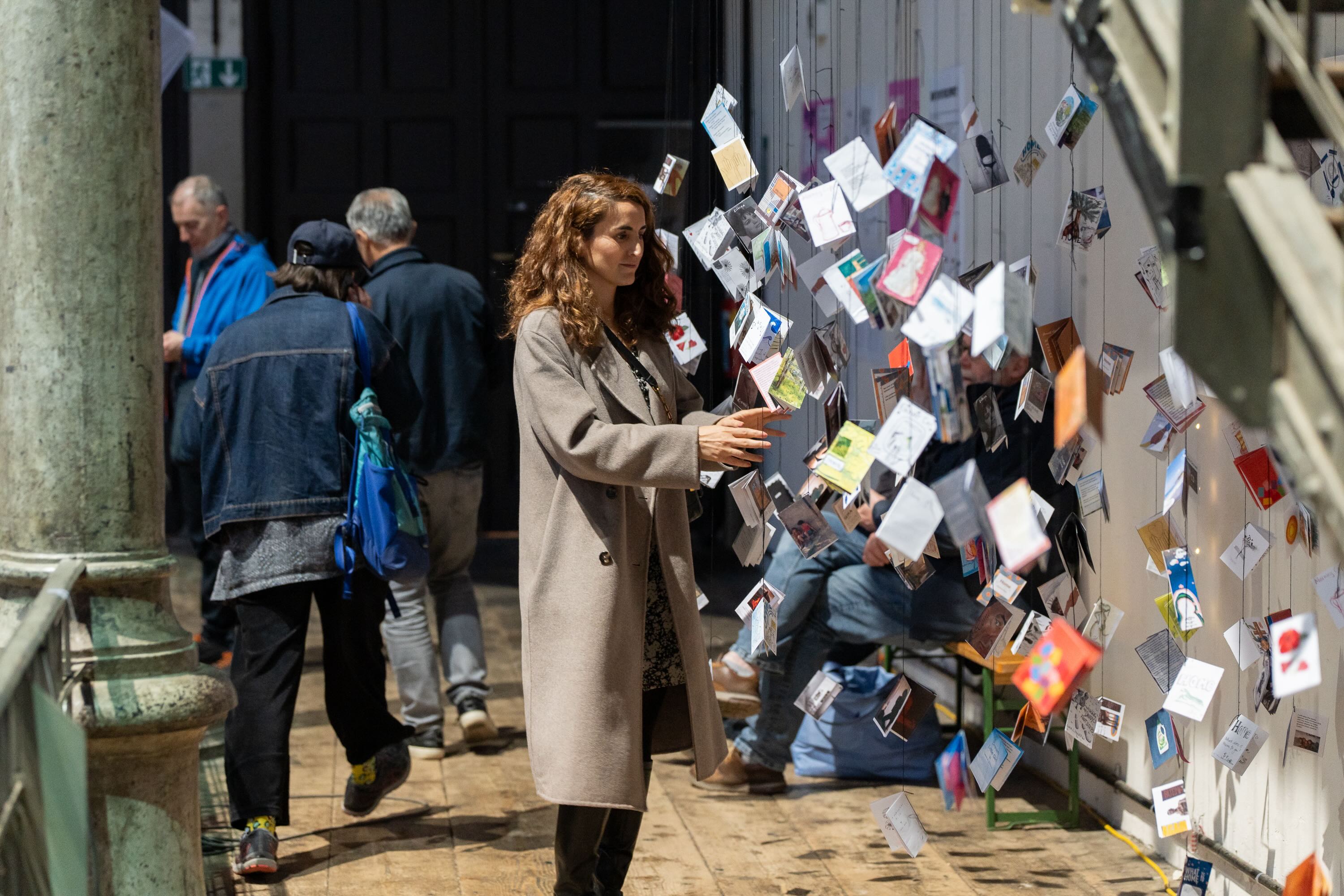 Visitor engaging with publications from remote participation at Fanzineist Vienna 2025
